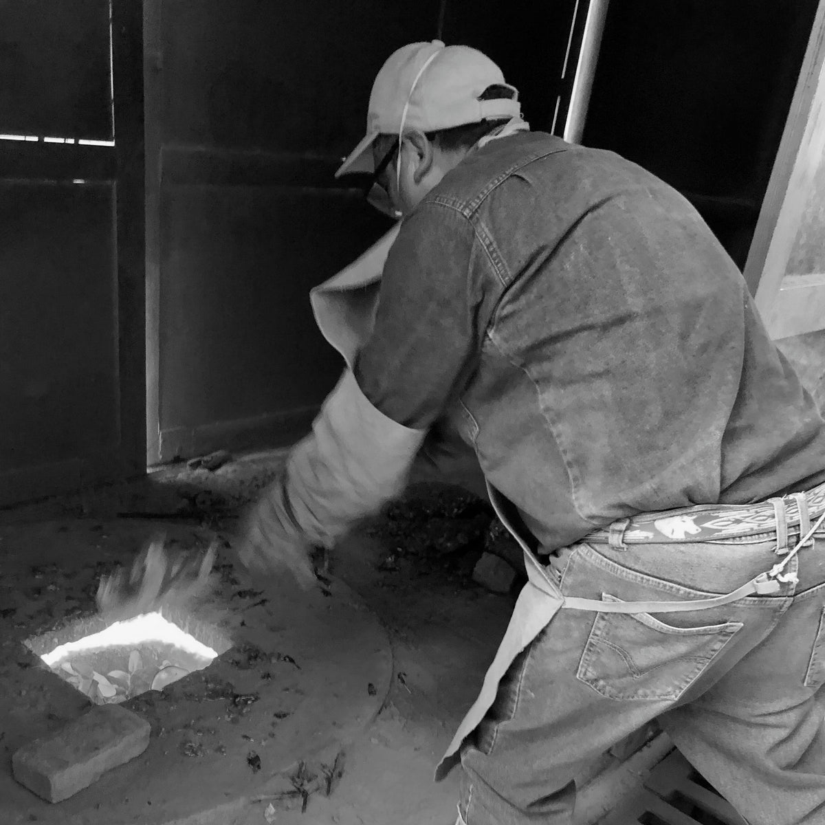 Artisan melting aluminum in preparation to pouring in sand cast mold