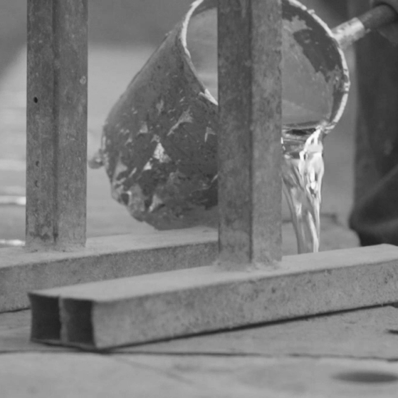 Artisan pouring melted aluminum into sand cast molds