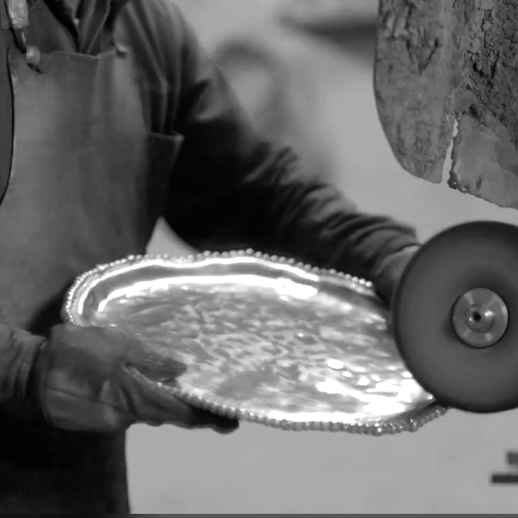 Artisan polishing a finished aluminum piece after taken from a sand cast mold